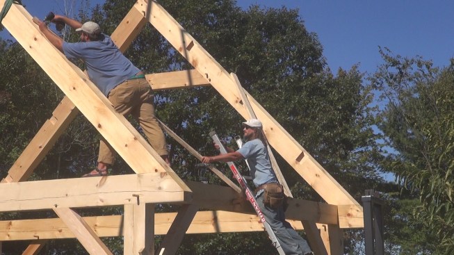 Chris and Toby screw temporary bracing onto the gable ends before starting to set purlins.