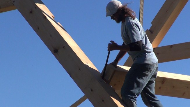 Toby pries a purlin end into position using a crowbar.