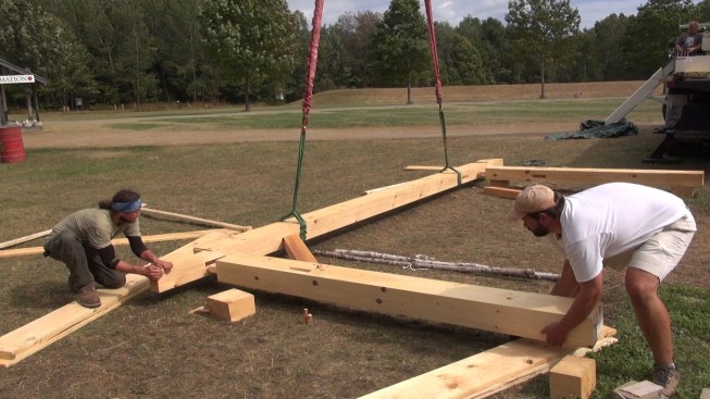 After lowering a wall bent to the ground, Chris and Toby pull the bent apart as the crane supports the weight of the plate.