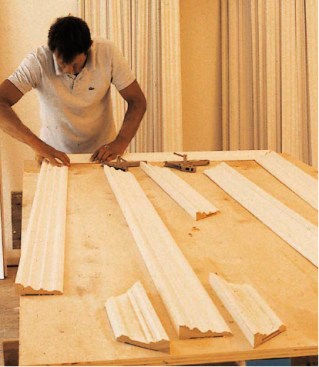 To create strong, tight miters, casing units are assembled flat on a work table using biscuits, glue, and clamps. The miter clamps were designed by the author and can be left in place while the casing is nailed up.