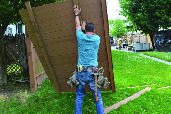 Installation started with demolition of the existing fence. After separating the panels from the posts, the author sawed the posts off just below grade, rather than try to remove them.