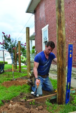 The author hammered pairs of 2x4 stretchers into the ground to temporarily hold the plumbed 6-inch-diameter PT posts in position while pouring concrete around the post bases. The post holes are 36 inches deep, or frost depth.