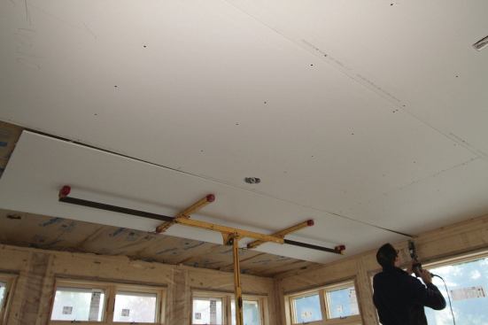 With a lift, I don’t need to worry about tacking a sheet in place—the lift will support the sheet against the joists, allowing me to fasten down the line of every joist.