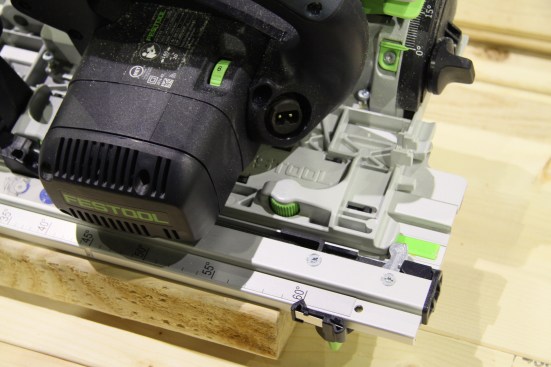 The stops register to the edge of the material, and the black anti-skid strips keep the track from moving as the saw travels through the cut.