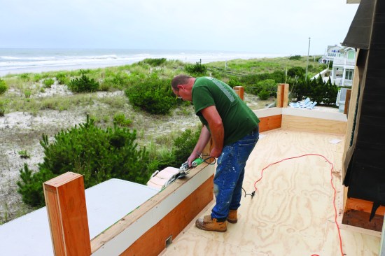 In addition to covering the subfloor with smooth 1/2-inch AC plywood underlayment, the crew eased the edges of the parapet wall with a grinder to prep the deck for the fiberglass contractor.