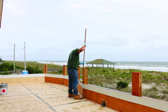 All the surfaces, including the top of the parapet wall, that would receive the fiberglass covering were primed with a “hot coat” of resin. The crew worked from the top down.