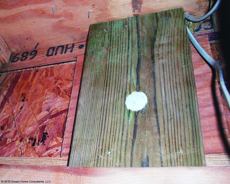 This ledger, on a year-old deck, was fastened to an I-joist rim board with carriage bolts; neither the fasteners nor the method are allowed by code, despite the blocking.