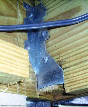 Metal hardware shouldn’t be field-modified; with its seat removed, this hanger provides minimal joist support.