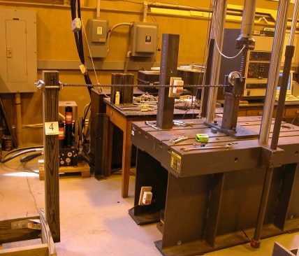 Here is the simulated deck joist/band/guard post configuration tested by the team at Virginia Tech. A chain was attached 37.5-inches (36” code required+1.5”) above the joists, over to a pulley, and up to a load cell. The test was conducted by raising the test machine load head which produced a horizontal force on the guard post.