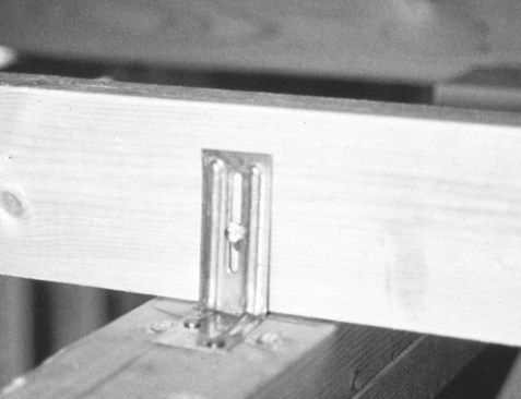 Instead of nailing trusses to wall plates, use truss clips as shown. The clips allow each truss to flex up and down freely, while preventing it from moving from side to side.