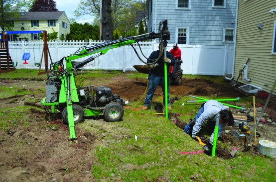 After digging a trench for the carrying beam, the crew used a hydraulic machine to drive helical piers into the soil until the required pier bearing strength was verified by the machine’s on-board torque gauge.