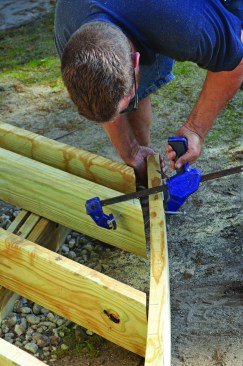 With the joists resting loosely on the carrying beam, the crew clamped the band joist into position.