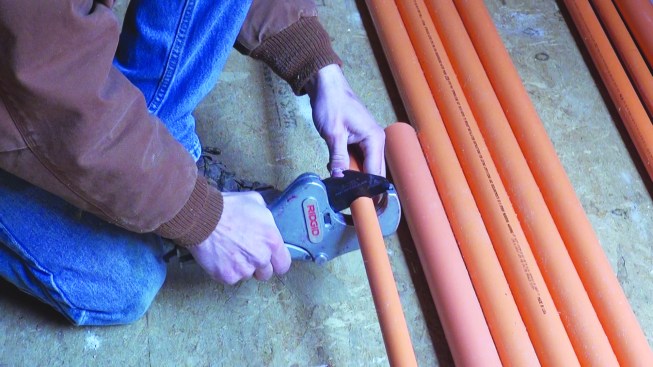 The CPVC piping shown on these pages is only one of a half-dozen or more permitted materials, but it’s widespread because of its versatility, affordability, and ease of use. Above, an installer cuts the tubing with hand shear.