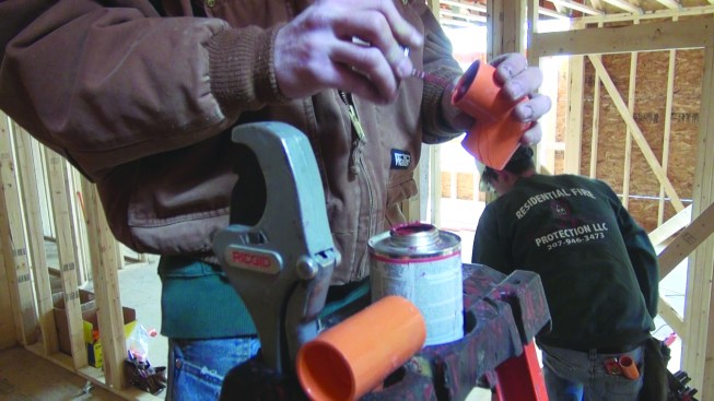 He applies a thick coat of solvent cement to the inside of a fitting.