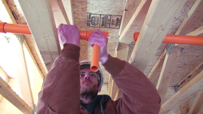 Then he jams the end of a pipe into a prepared fitting.