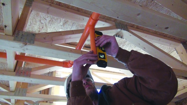 The pipe is checked for plumb.