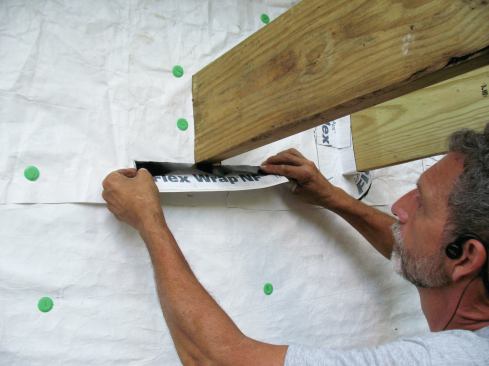For 2x8 joists, I cut 11 1/2-inch-long, 5-inch-wide pieces of flashing tape. I peel off a 1 1/2-inch strip of release paper to attach that part of the tape to the joist while the remaining 3 1/2-inch-wide portion of the tape stays protected by release paper.