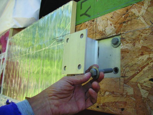 Maine Deck Brackets are bolted directly to the rim joist, so the first step is to cut out the wall sheathing and through-bolt the wider flange to the rim.