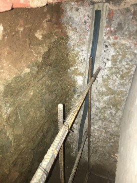 Typically, the rebar cages are wired up with extensions driven into the dirt on each side so they overlap and are wired to rebar in the adjacent sections.