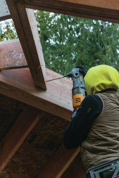 We added extra studs to the rake walls where the valleys intersected the wall to create full-height structural columns. We then fastened the valleys to the face of these columns using FastenMaster TimberLok screws, which will be loaded in shear. 

