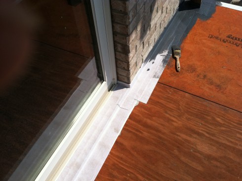 After flashing the joint between the deck and the wall with aluminum, the author sealed the metal flashing to the plywood with selfadhesive seam tape.