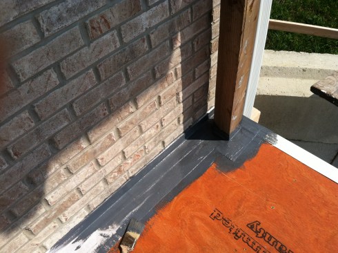 The taped seams and flashed guard posts needed to be embedded with the Super Elasto-Barrier rubberized coating, which the author applied with a brush.