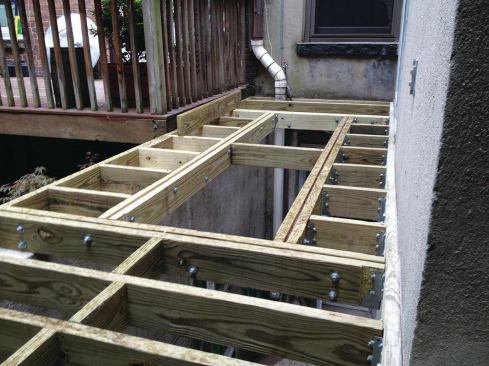 The deck framing is partially supported by a concrete-block separation wall. Doubled 2x6 joists used to frame the rough opening for the skylight were reinforced with 1/4-inch by 5-inch steel plates.