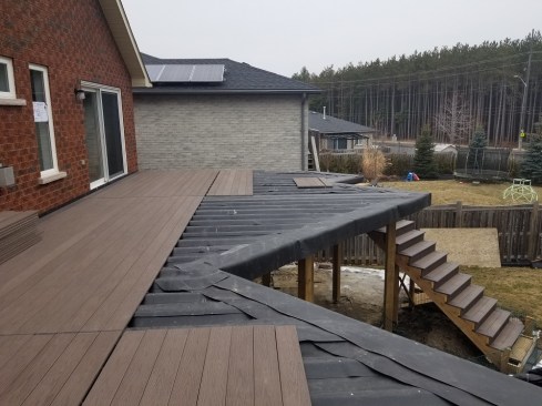 Making the deck waterproof using an EPDM membrane from above means added durability and a useful space below the deck. Lighting and ceiling fans and even drop down screens or curtains can be added later for privacy and insect protection.