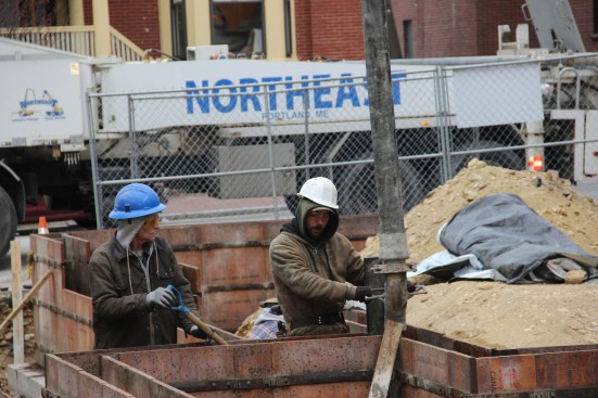The crew pours a stiff mix, with a four-inch to five-inch slump. Shovel work is part of the process.