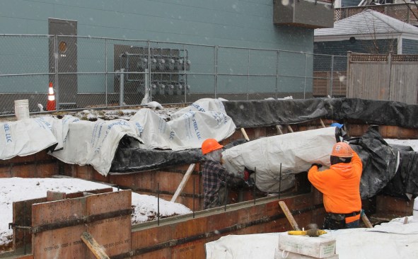 With snow starting to fly and weather cooling at the end of the day, the crew covers the walls with insulating blankets.