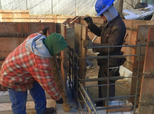 Crew members set forms and tie rebar.