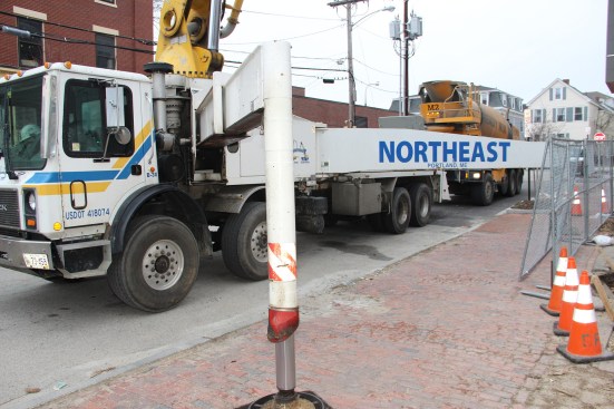 A pump truck supplied by Northeast Concrete Pumping (Scarborough, Maine) in place by the curb at the jobsite. Parking and traffic control are part of the problem project manager Jeff Barker has to solve. 