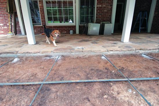 The rebar reinforcement in a patio extension must be pegged to the old slab to prevent differential settling. 