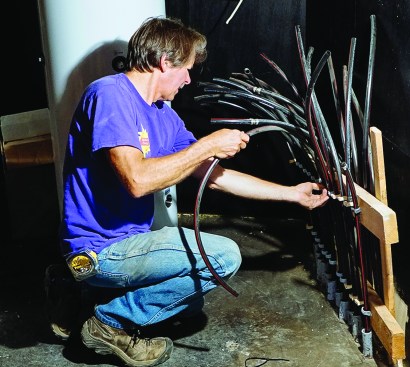 ReVision Energy’s Chris Blaisdell works on the hydronic tubing for a radiant slab in a
custom house. Behind him is the hydronic buffer tank for the system.