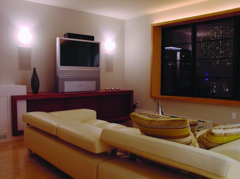 Expert touches in this Sergio Mazon lighting project help this house work and feel better: Wall sconces sit behind the TV so as not to cast glare on the screen.