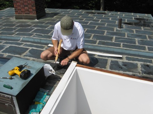 Low-slope copper roofs must be fully soldered, with pans sized no larger than 18 by 24 inches. Movement joints (seen to the rear of the carpenter) are necessary on larger roofs.