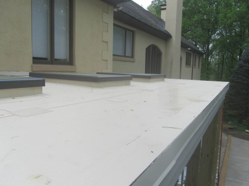 TPO makes a neat, attractive roof that clients often prefer to EPDM. In the roof edge shown here, the TPO has been turned down over the face of the trim about 2 inches, then the metal drip edge has been applied over the membrane. Finally, a strip of TPO has been welded on top to cover the metal. This prevents leaks at the joints in the metal.