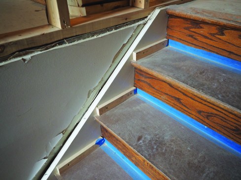 Hardwood stairs can be protected using hardboard or plywood tread covers, secured to skirtboards using cleats.