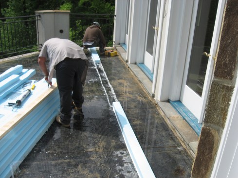 The crew built a low dam using strips of foam caulked to the existing waterproofing and flooded the roof edge.