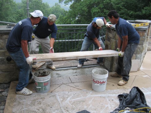 Finally, they set new stone pavers into the wet mortar.