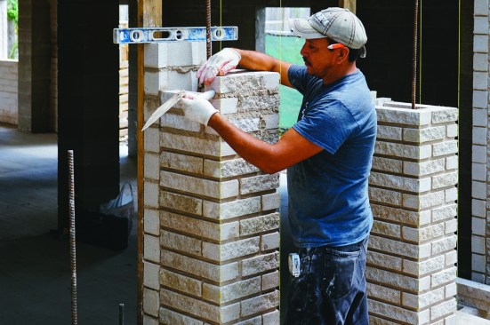 Exterior decorative details are also key. Here, a mason clads a new exterior column on the street side of the building.