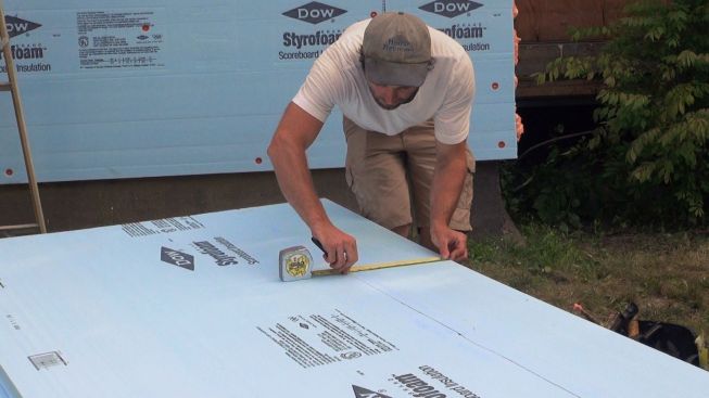 David Kelly scribes a piece of Dow Styrofoam as he pieces together the XPS insulating drainage plane for the house.