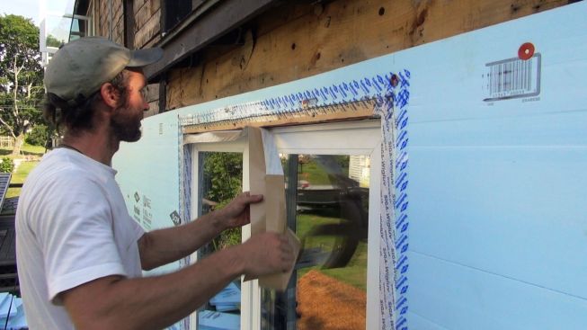 Kelly applies more Sega Wigluv tape at the top of the window.