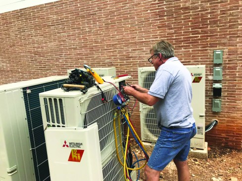 Gilbert Rosipal of Air Rite By Design of Austin, Texas, wires up a Mitsubishi variable refrigerant flow (VRF) outdoor unit. Controls in the compressor allow the system to ramp its power up and down gradually, dialing back to as low as 15% of full capacity when appropriate to address “part-load” conditions.