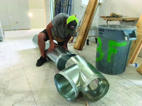 An installer for Air Rite By Design of Austin, Texas, assembles metal ductwork on a jobsite. Positive Energy specifies metal duct for all installations because of its durability and for sanitary reasons. Once installed, the ductwork is buried inside permanent building assemblies and is difficult and expensive to access or replace, so durability is a key aspect of quality.