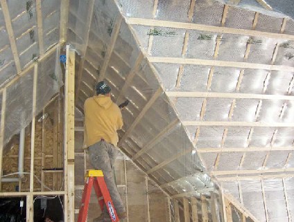 Triple-ply Par/Pac membrane is stretched around framing edges and rigorously stapled to prevent the cellulose insulation from bulging past the wall plane. Cellulose is blown through slits in the membrane to a density of 3.5 pounds per cubic foot. The slits are then resealed with tape.