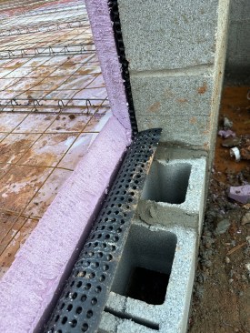 Insulation detail at french door opening at the back (walkout) side of the basement. Note the dimple mat installed at the base of the foundation walls along the entire perimeter. This will provide a drainage cavity behind the rigid insulation that will be applied to the walls.