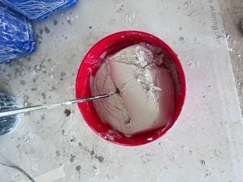 The author typically empties a box of joint compound into a 5-gallon bucket. Out of the box, the material is dry and stiff.