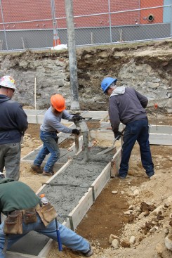 A mason crew with JB Concrete Foundations (Bridgton, Maine) places concrete footings for a four-family infill project in Portland, Maine. A four-inch slump was specified for this job.