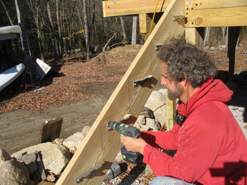 After setting the brackets, pilot holes are drilled for structural screws to be driven through the outside of the stringers and into the end of the treads to help keep the assembly tight. 